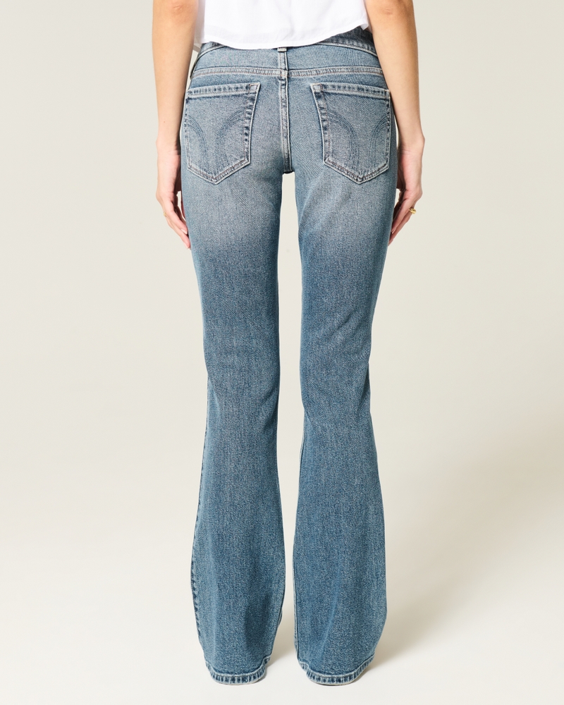 hüftig geschnittene mittelblaue bootcut-jeans mit blumenstickerei.