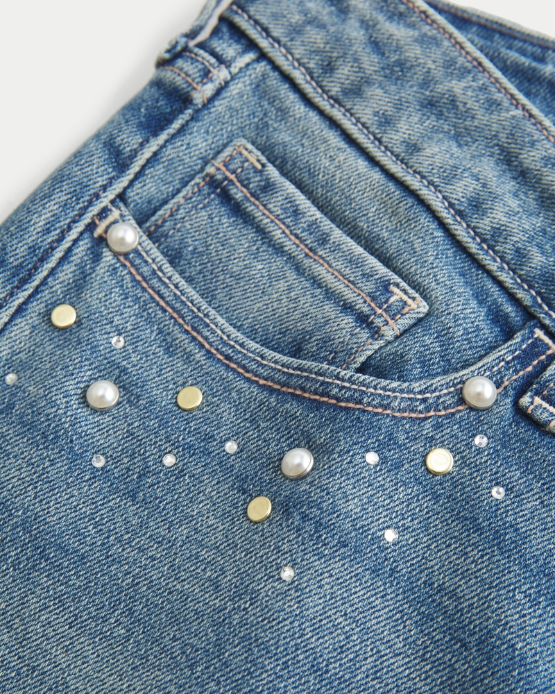 hüftig geschnittene mittelblaue bootcut-jeans mit blumenstickerei.