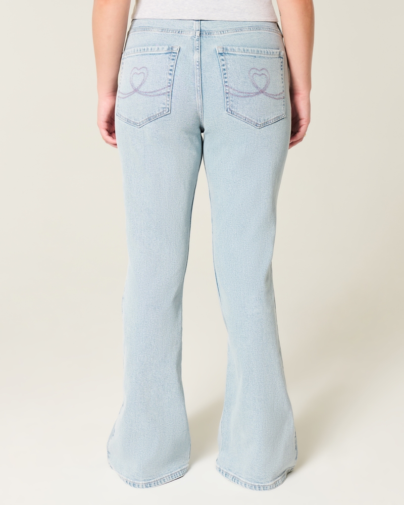 hochgeschnittene hellblaue jeans mit herzförmigen taschen und ausgestelltem bein