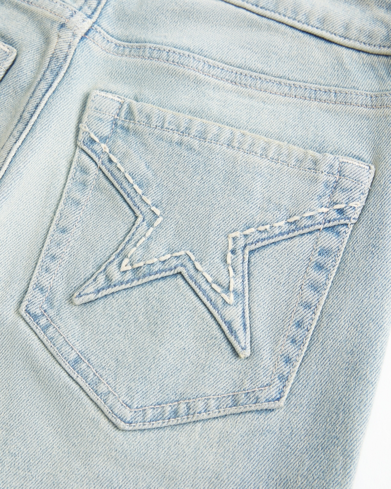hochgeschnittene hellblaue jeans mit herzförmigen taschen und ausgestelltem bein