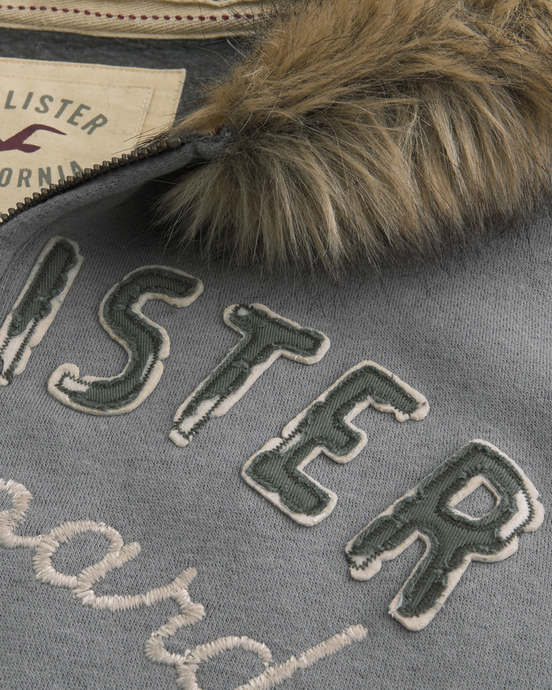 kapuzenpullover aus wildleder mit reißverschluss und kunstpelzbesatz sowie großem sonnenmuster